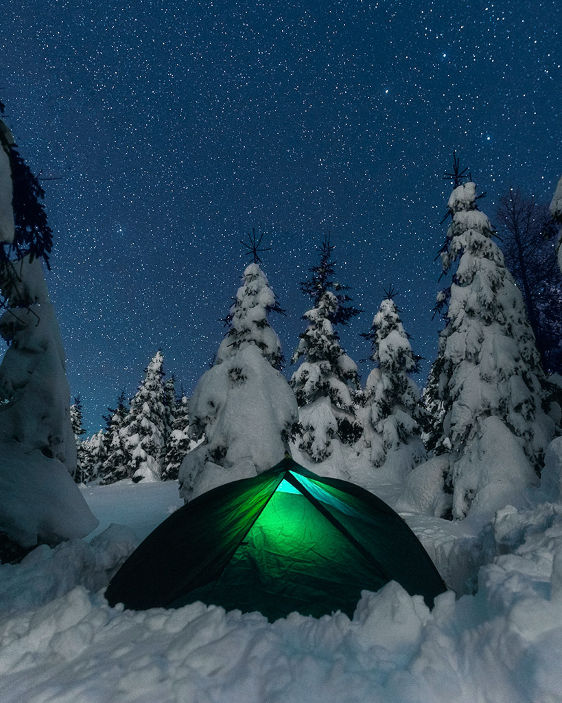 winter tent camping adventure in snow covered trees smrezaki