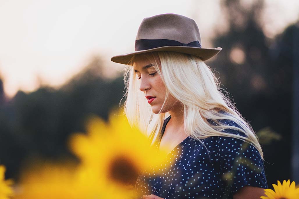 serious femlae portrait in the middle of the sunflower field